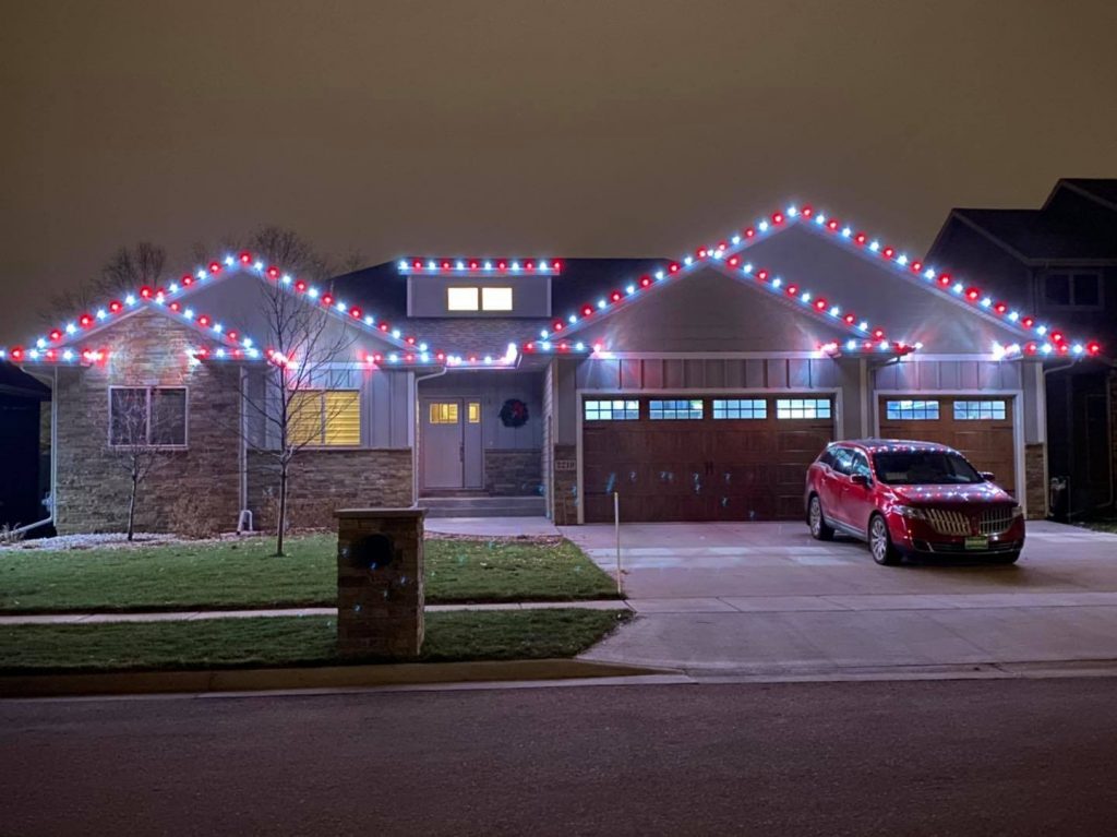 Residential home decorated with colorful holiday lights on the roof, showcasing festive ambiance and seasonal charm, emphasizing specialized lighting solutions for outdoor spaces.