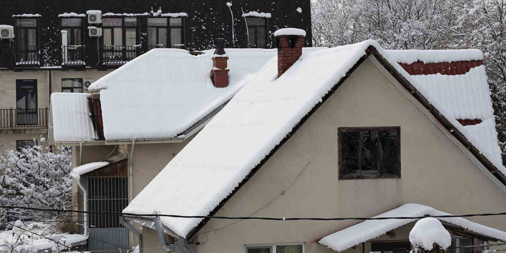 Snow-covered roofs of residential buildings, illustrating snow accumulation, relevant to snow removal concerns and roof safety.