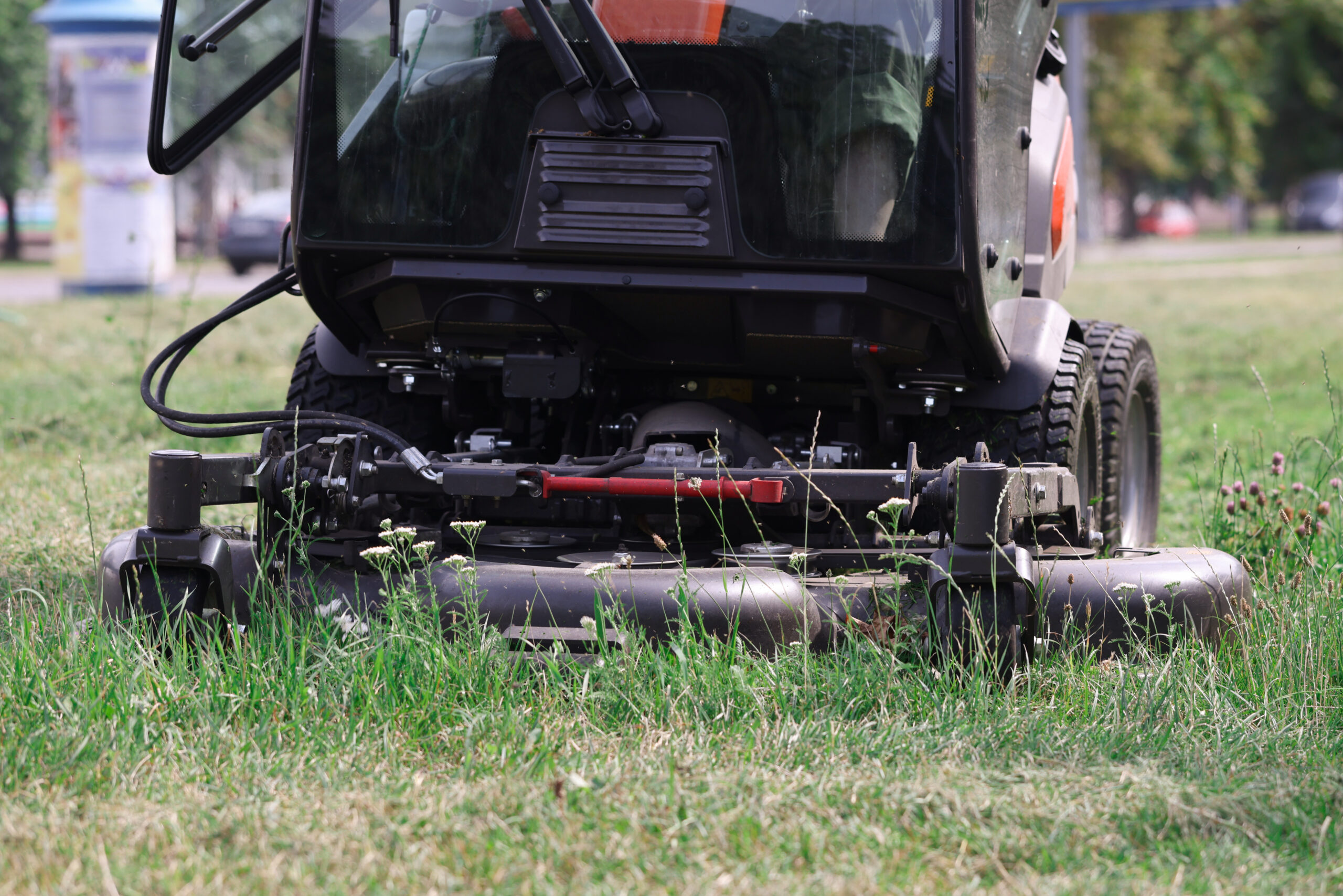Lawn aeration equipment in action, showcasing a machine designed for improving soil health and promoting lush grass growth, surrounded by green grass and wildflowers.